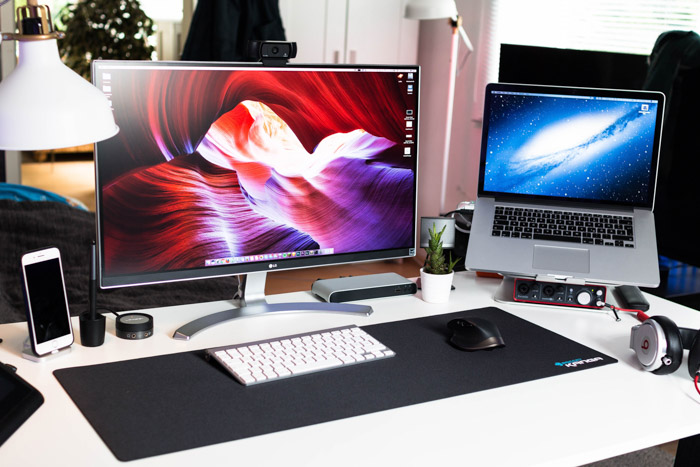 An office desk with a desktop company and a laptop - best image resolution for printing