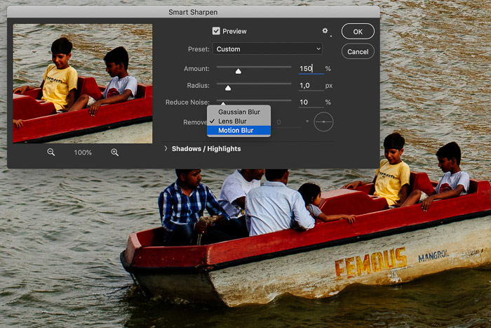 Screenshot of editing a picture in Photoshop showing a row boat in India. The Smart Sharpen setting are open in this screenshot and the Motion Blur is selected from the drop down menu.