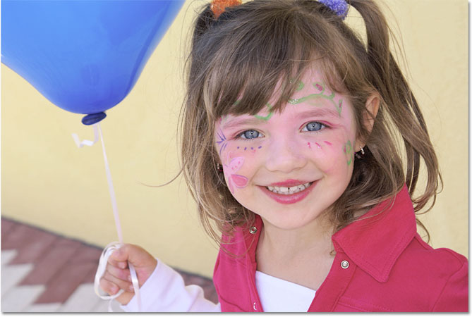 A young girl holding a blue balloon. Image © 2010 Photoshop Essentials.com